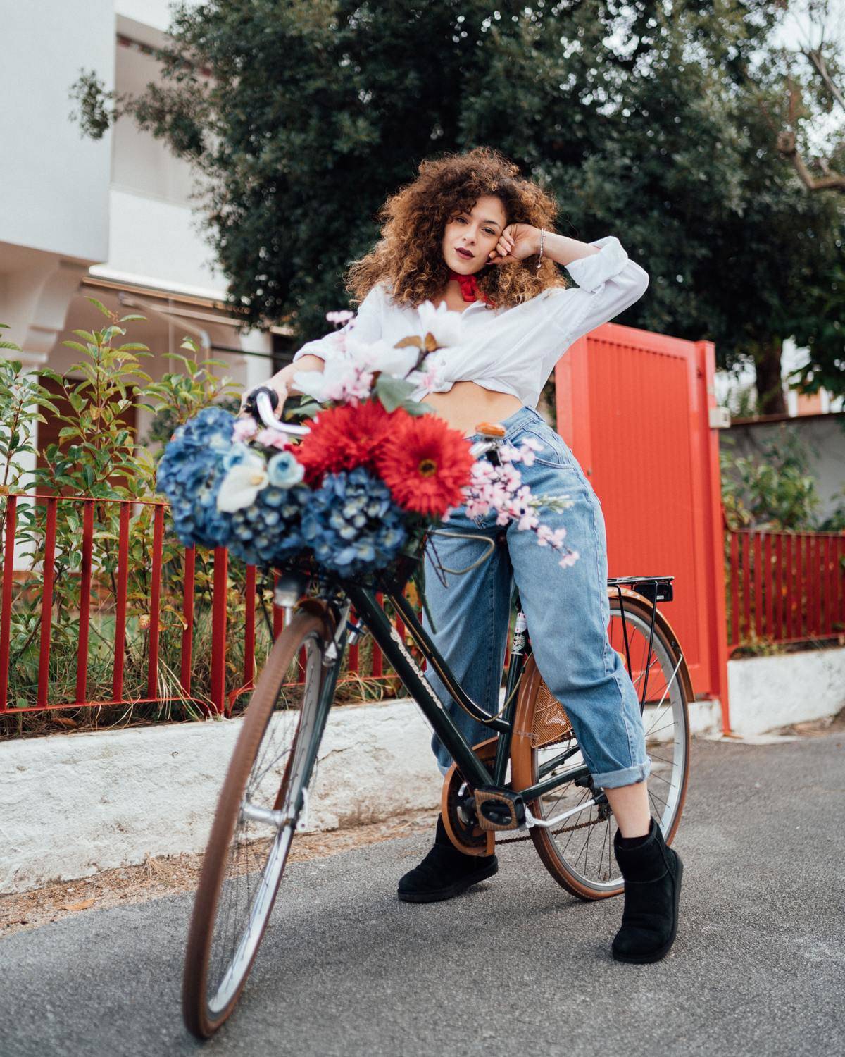 woman riding a bike with a bunch of flowers on it