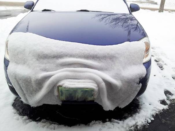snow melting on a car's hood looks like a white blanket