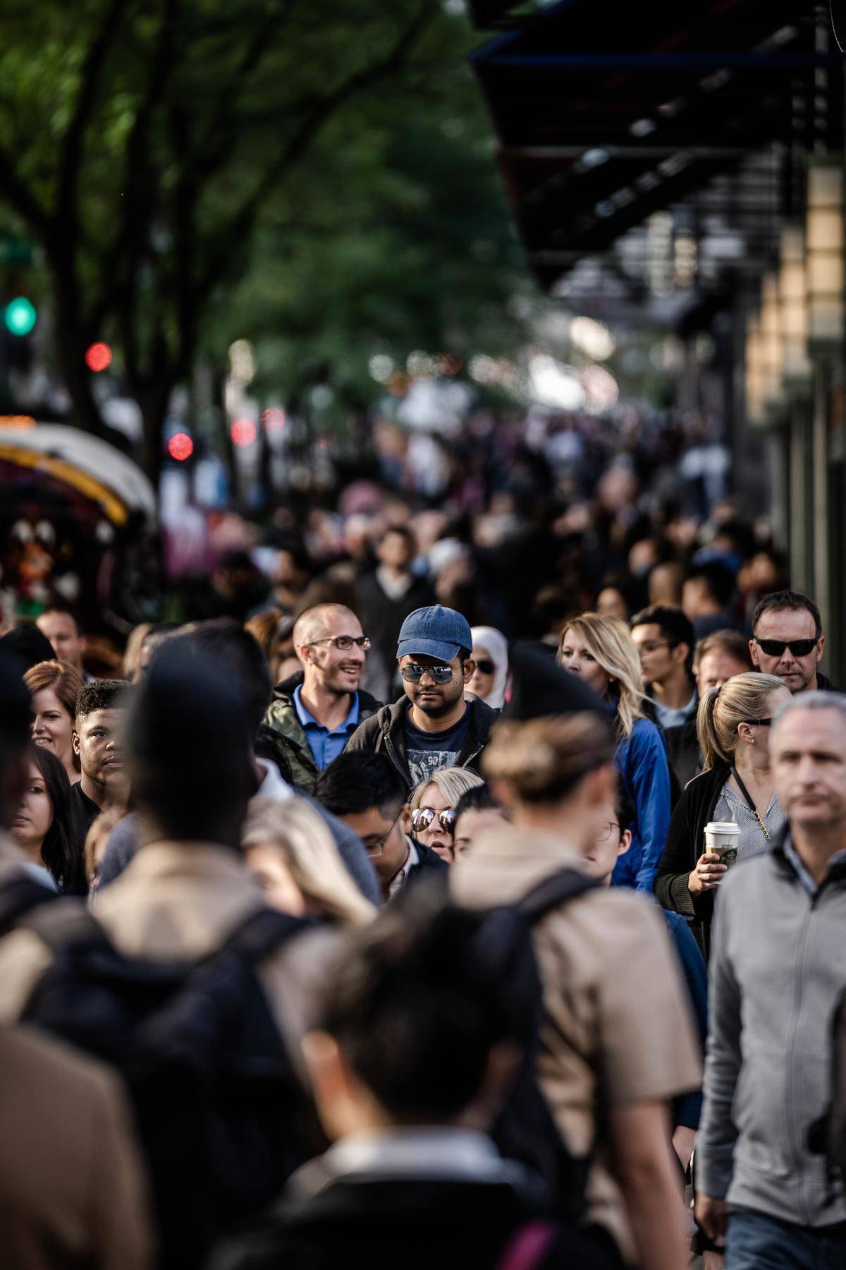 men and women walking on busy city sidewalk
