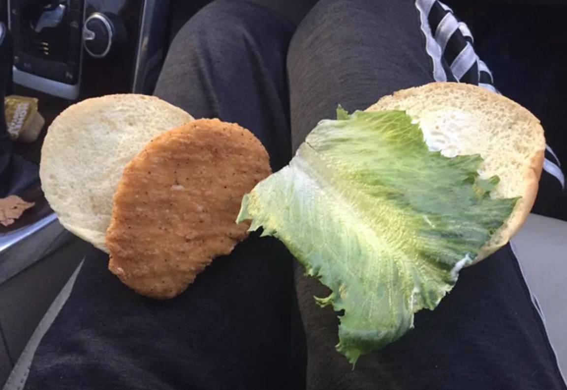 two pieces of bread, breaded chicken patty, and a piece of romaine lettuce
