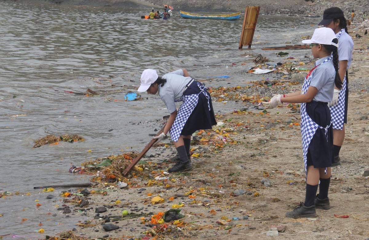 Volunteers clean trash from Chowpatty beach, Mumbai.