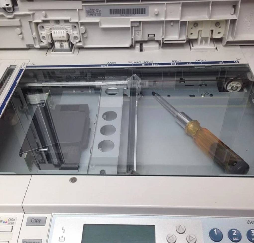 screwdriver stuck under the screen of the copy machine