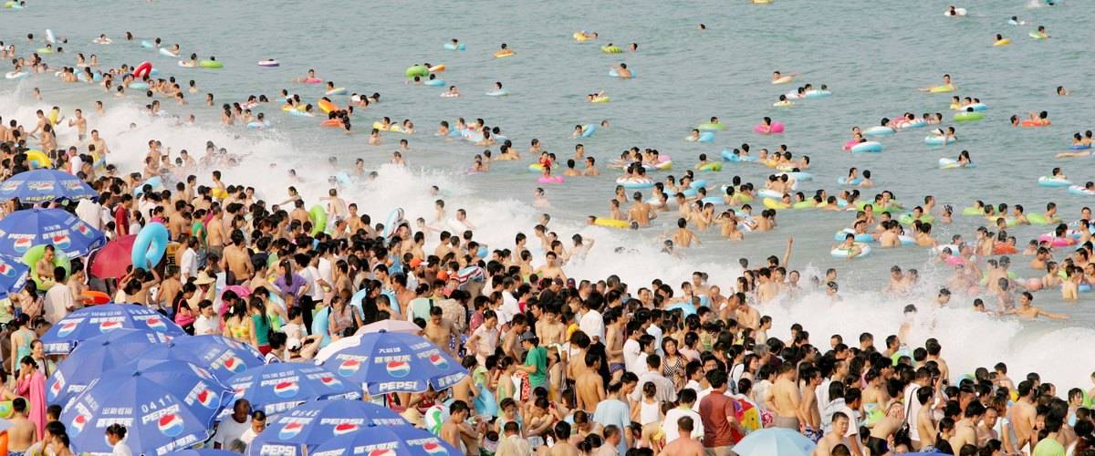 Swimmers crowd the shore and waters of  Dameisha Beach, China.