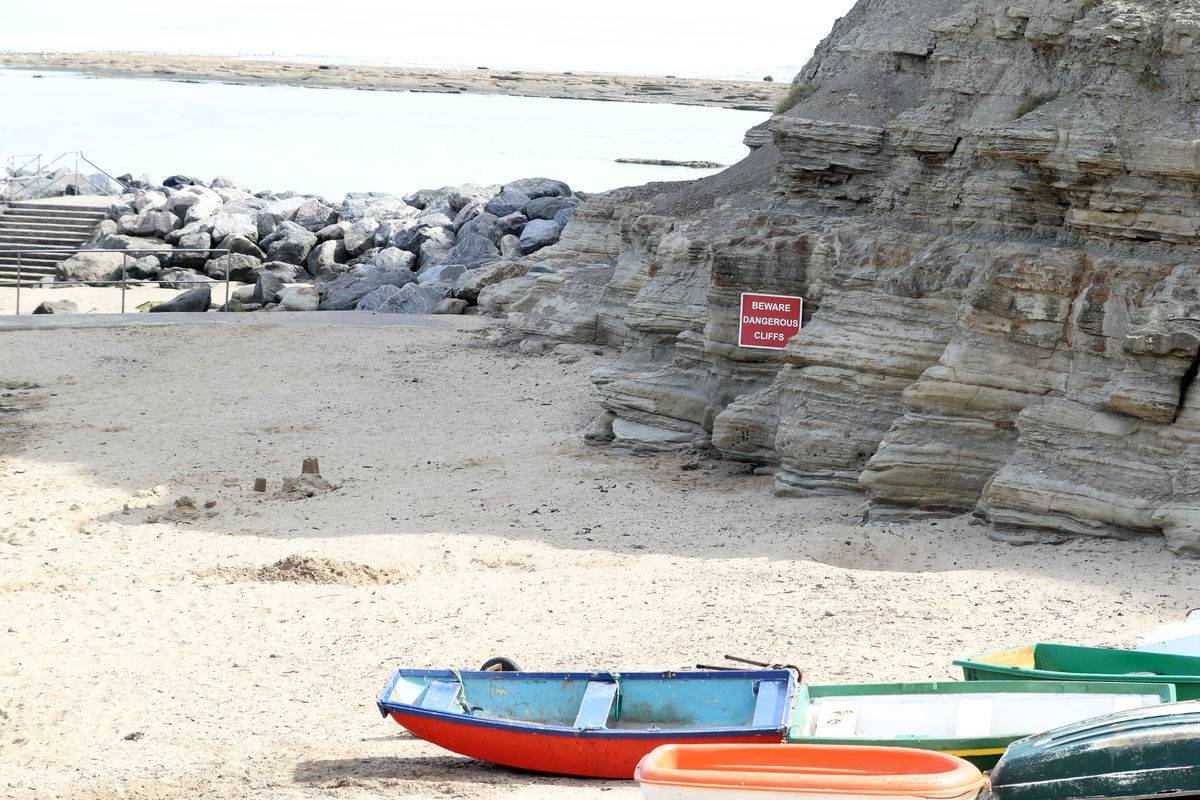 A sign on Staithes beach warns people about dangerous cliffs.