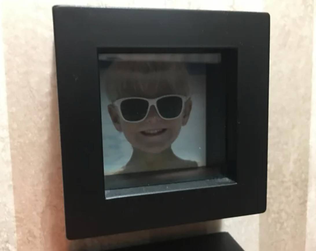 framed photo of boy wearing sunglasses hung on wall