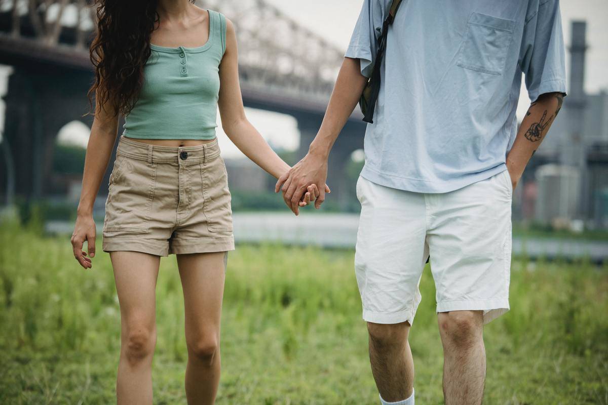 bodies and legs of man and woman holding hands