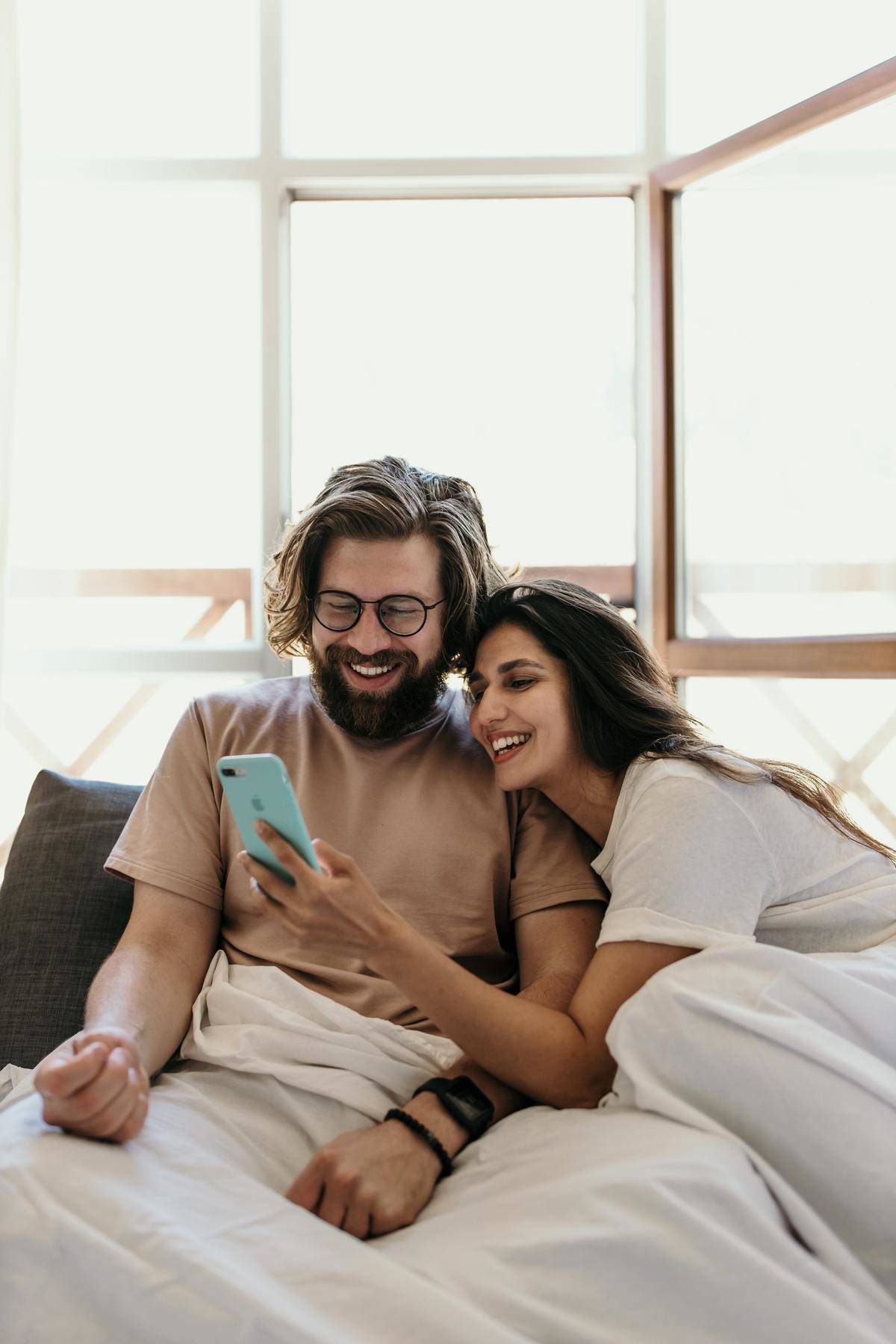 couple laughing while looking at phone