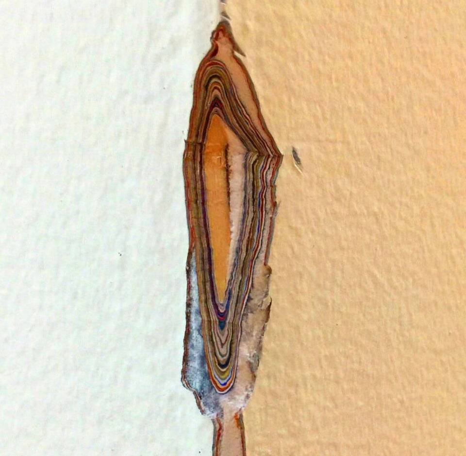 A wall corner is exposed, showing layers of paint.