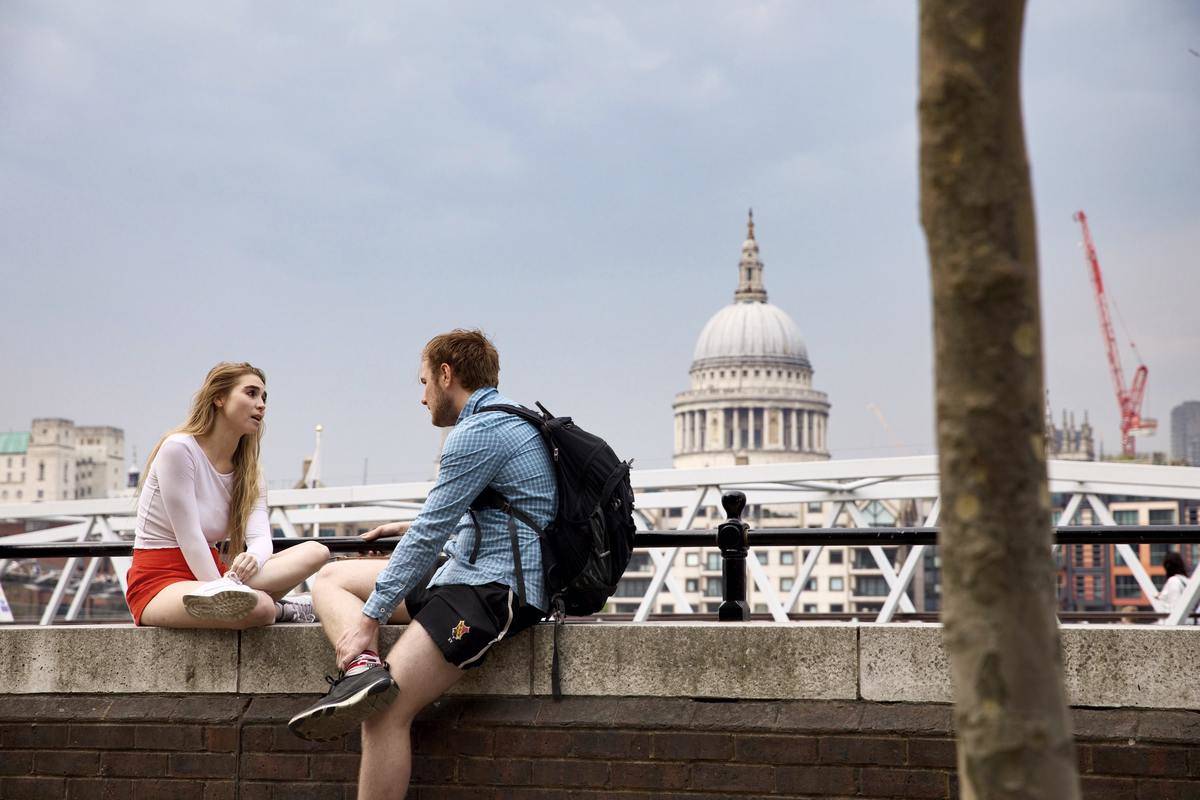 man and woman sitting outside, talking