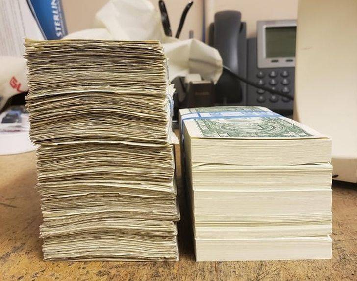 A new stack of single dollar bills beside a stack of old bills