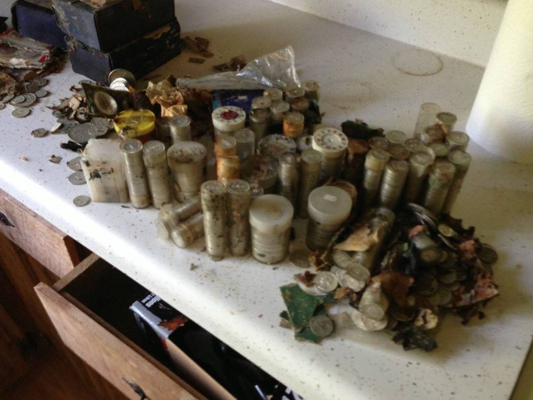 Stacks of old coins from a safe are piled on a table.