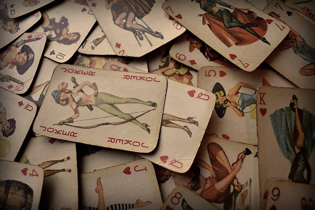 A pile of old vintage playing cards is seen.