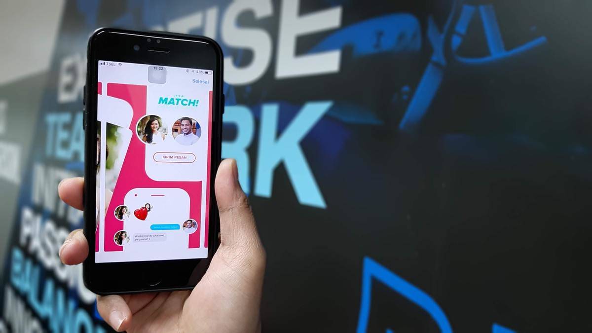 phone screen shows Tinder match on screen