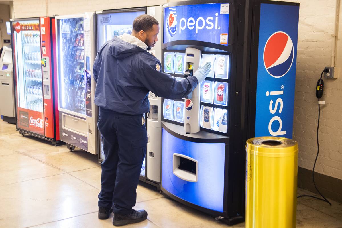 An Architect of the Capitol employee uses a disinfectant wipe on a vending machine in Cannon Building to combat the spread of the outbreak on Thursday, March 12, 2020.