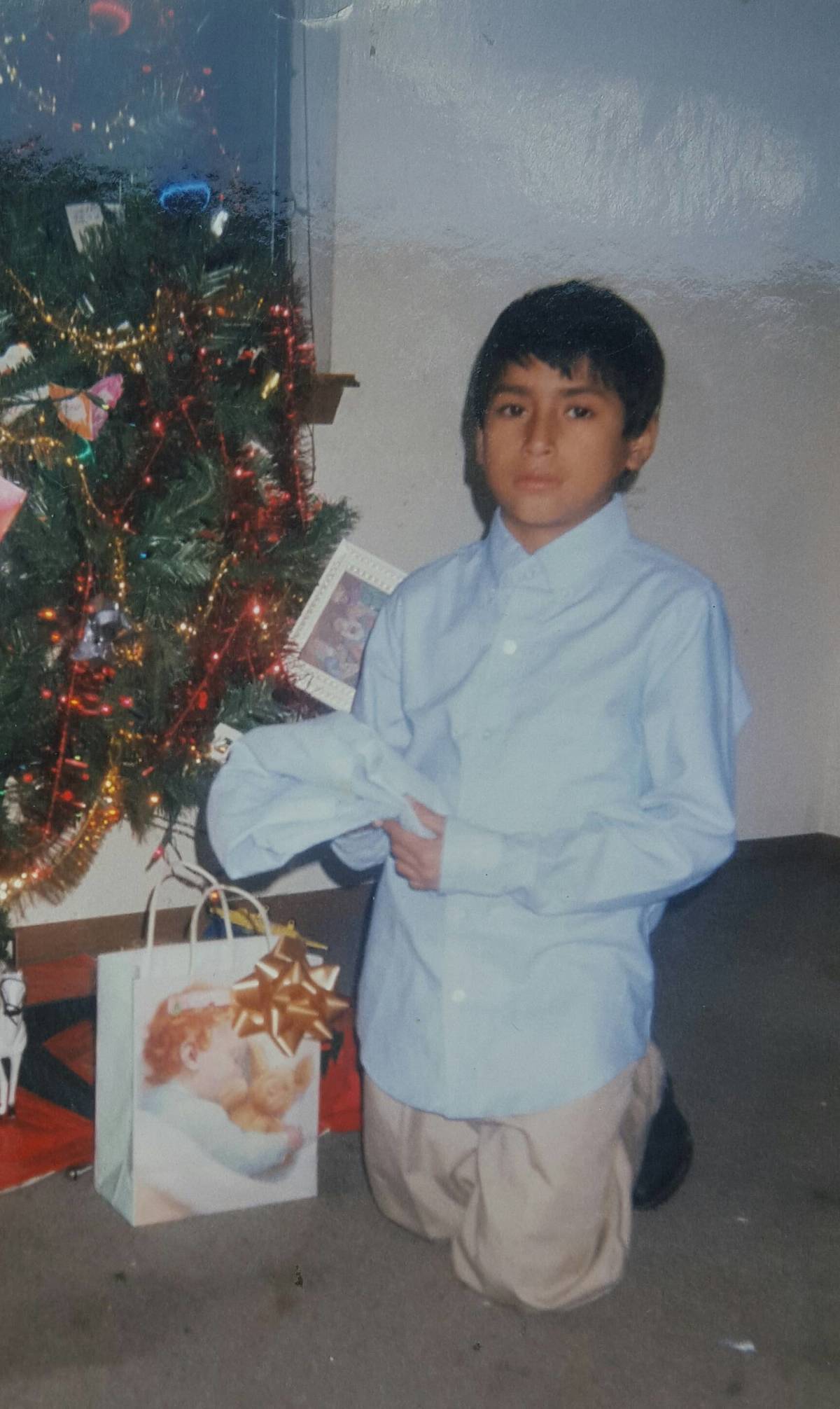 11 year old boy opening dress shirt as christmas present that is same as one he's wearing