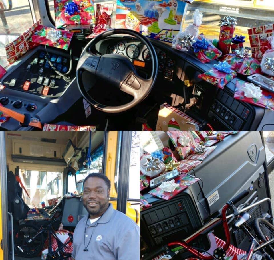 bus driver poses with bus full of gifts