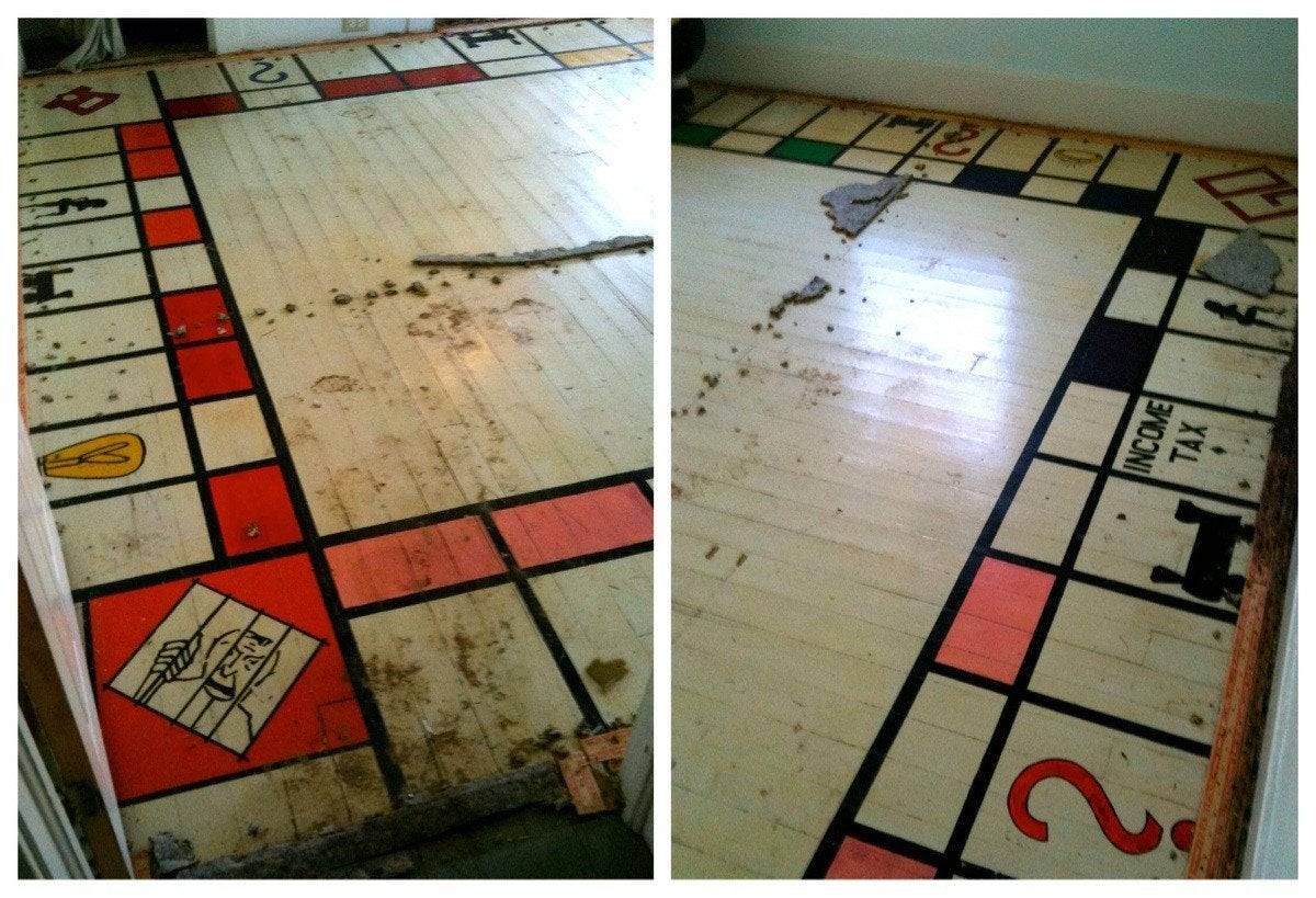 A giant risque Monopoly board is seen underneath a carpet.