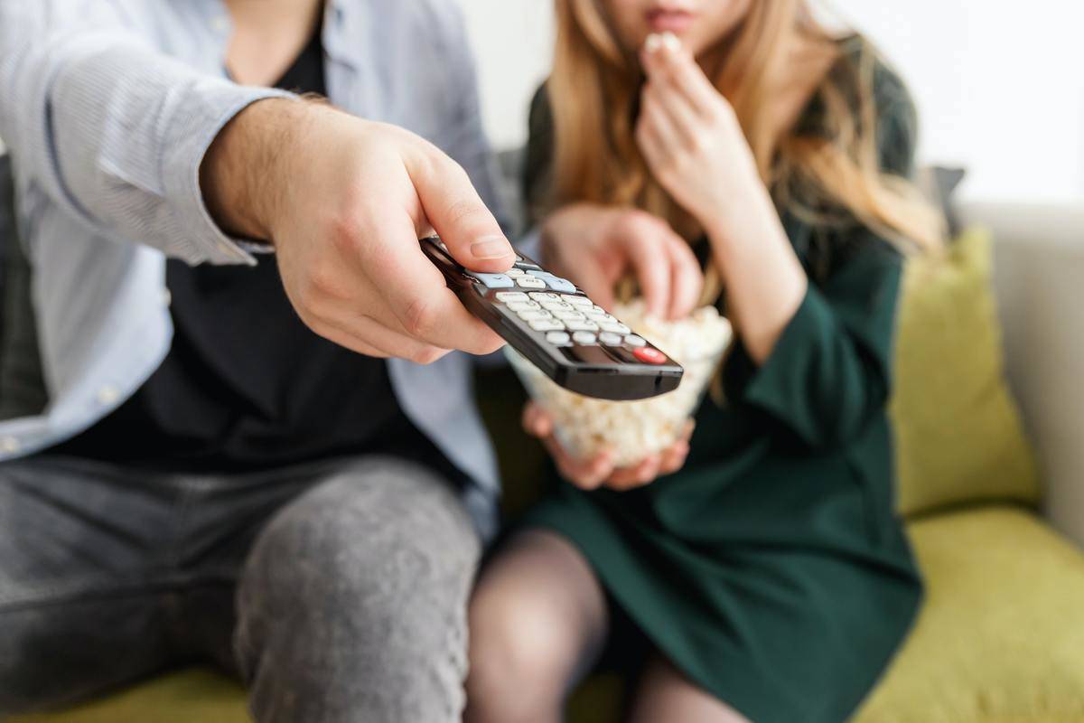man and woman on couch with t.v. remote