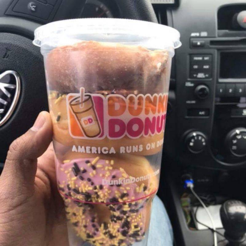 three donuts in a Dunkin Donuts plastic cup