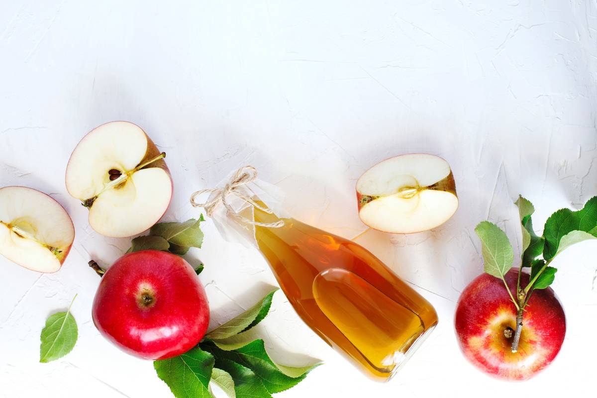 Apple cider vinegar and fresh apples, top view