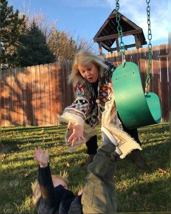 Mother diving to catch her child who has fallen off a swing