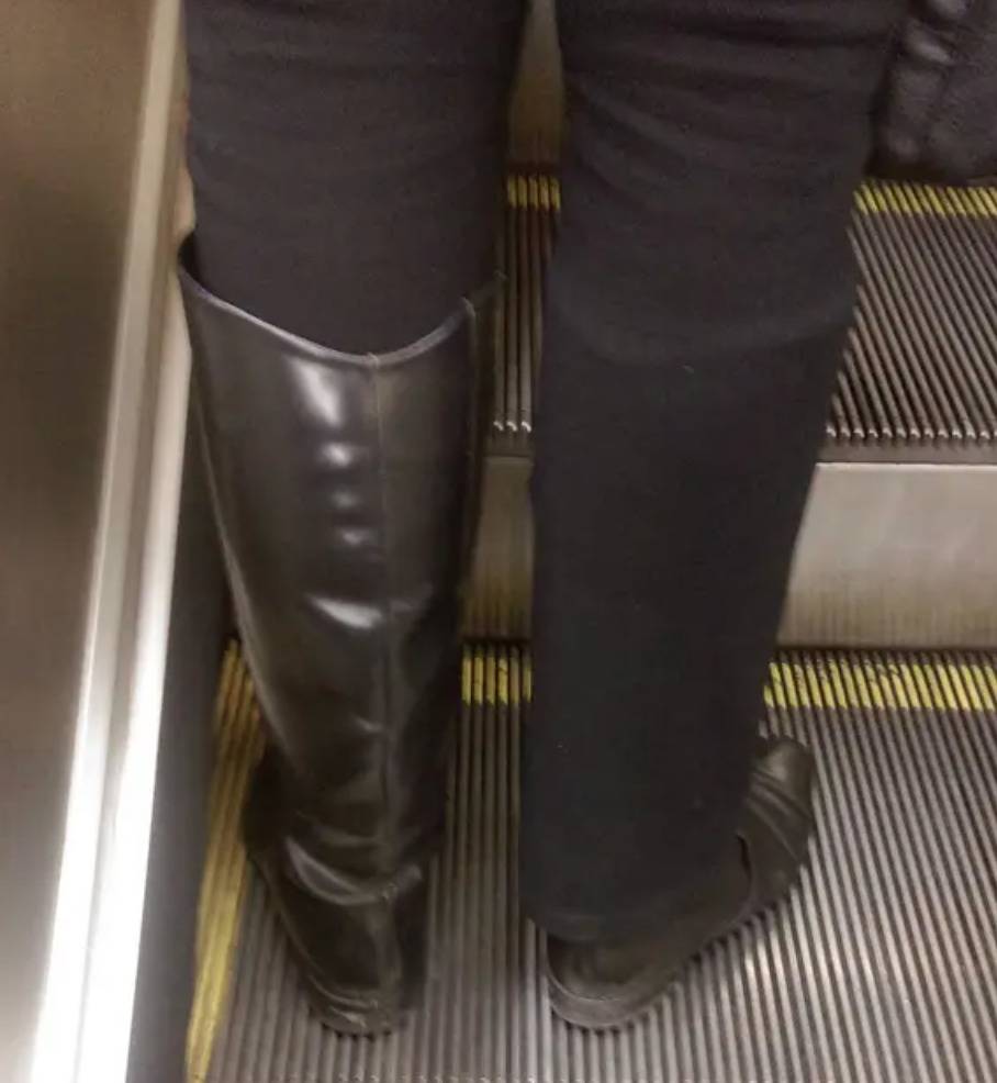 woman has pant leg tucked into one knee high boot and over the other