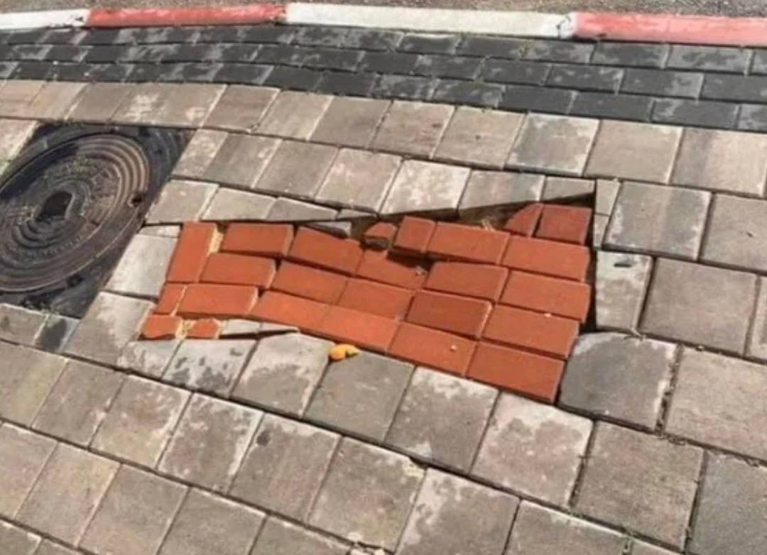 wrong color/size bricks shoved unevenly into hold in sidewalk