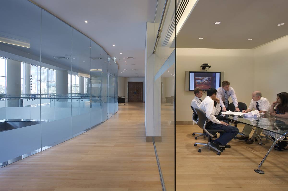 Multiple people sit around a business meeting.