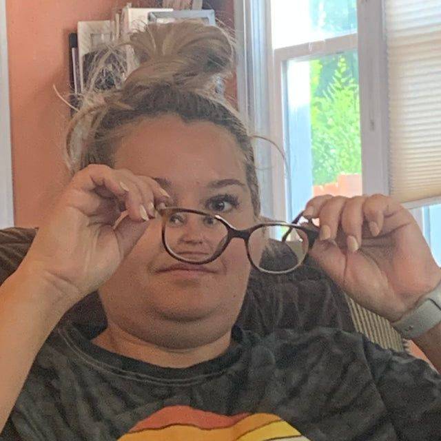 unflattering photo of woman putting on glasses