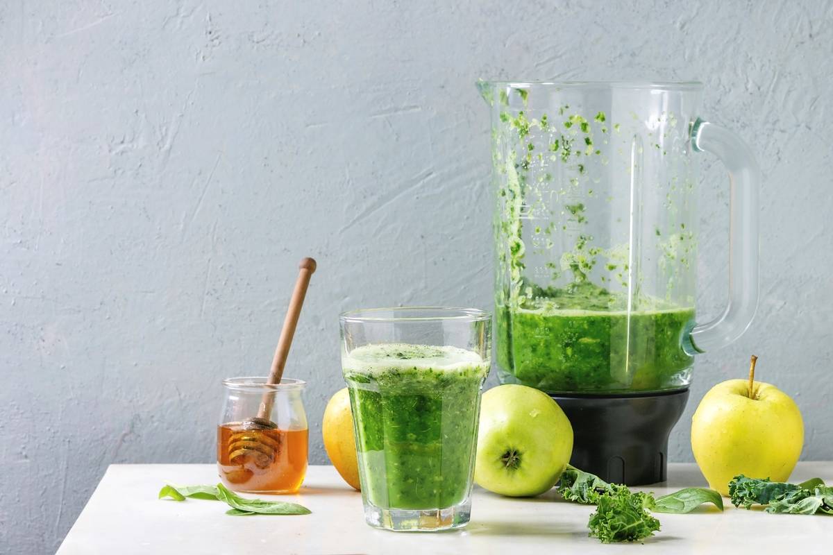 smoothie on table with blender and ingredients