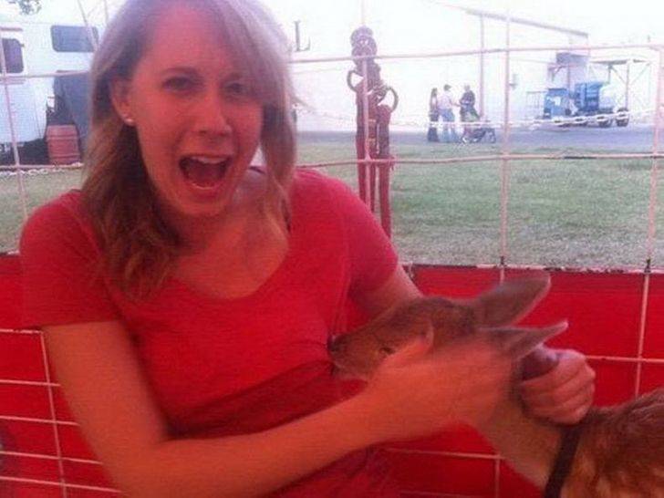 Woman at petting zoo being bitten in the chest by a deer