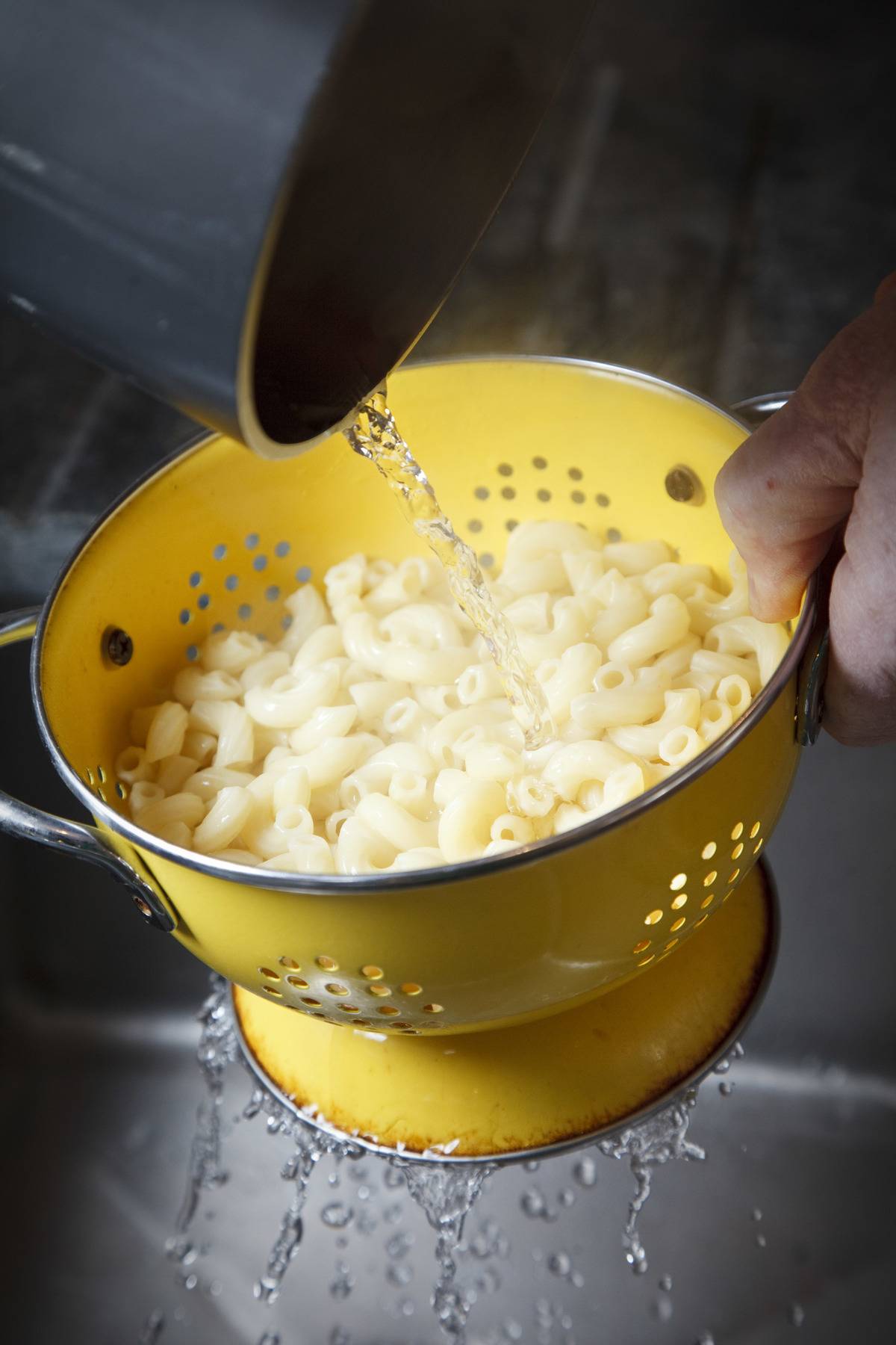 Macaroni noodles in a yellow strainer 