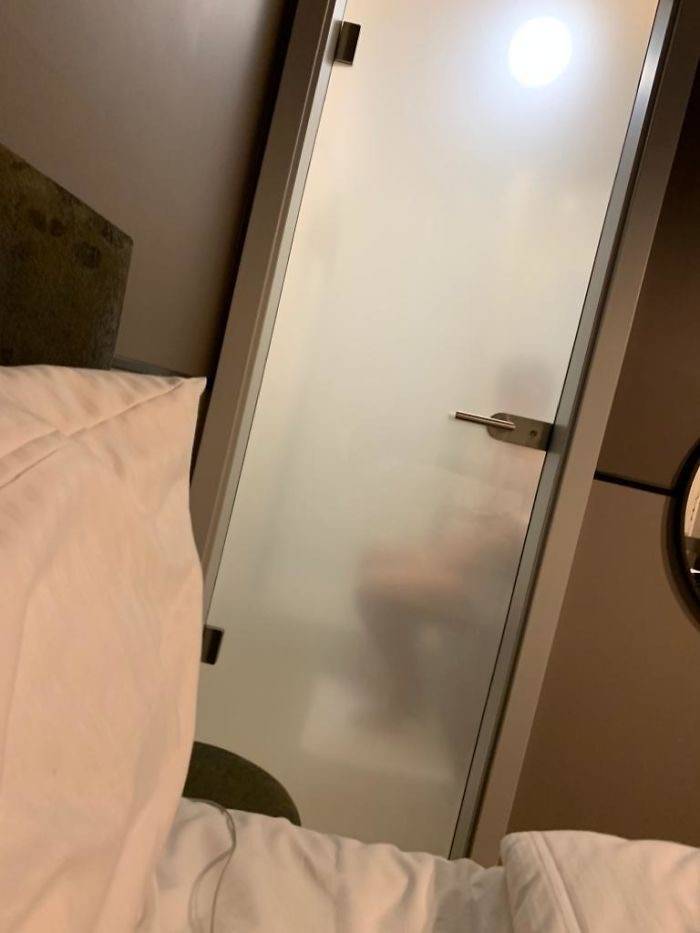 bathroom door see through with person using toilet