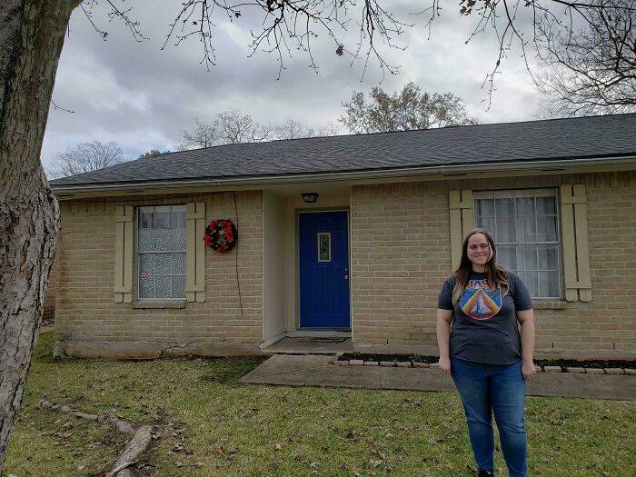 woman standing next to new house