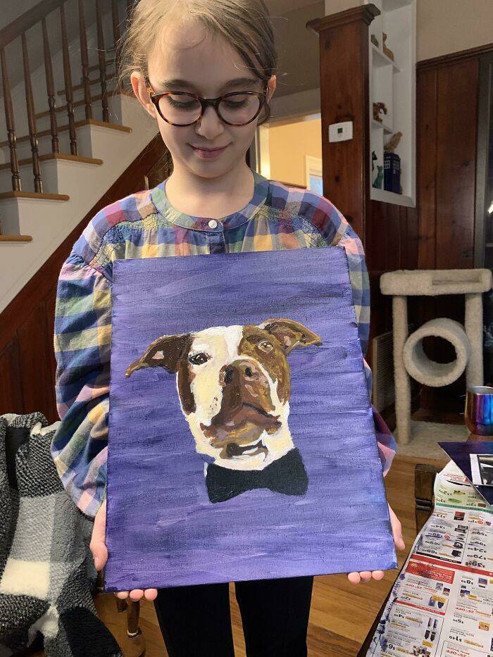 girl holding painting of dog