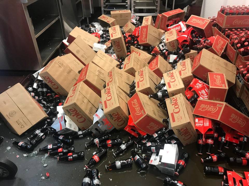 hundreds of boxes of broken coke shipment left to clean up