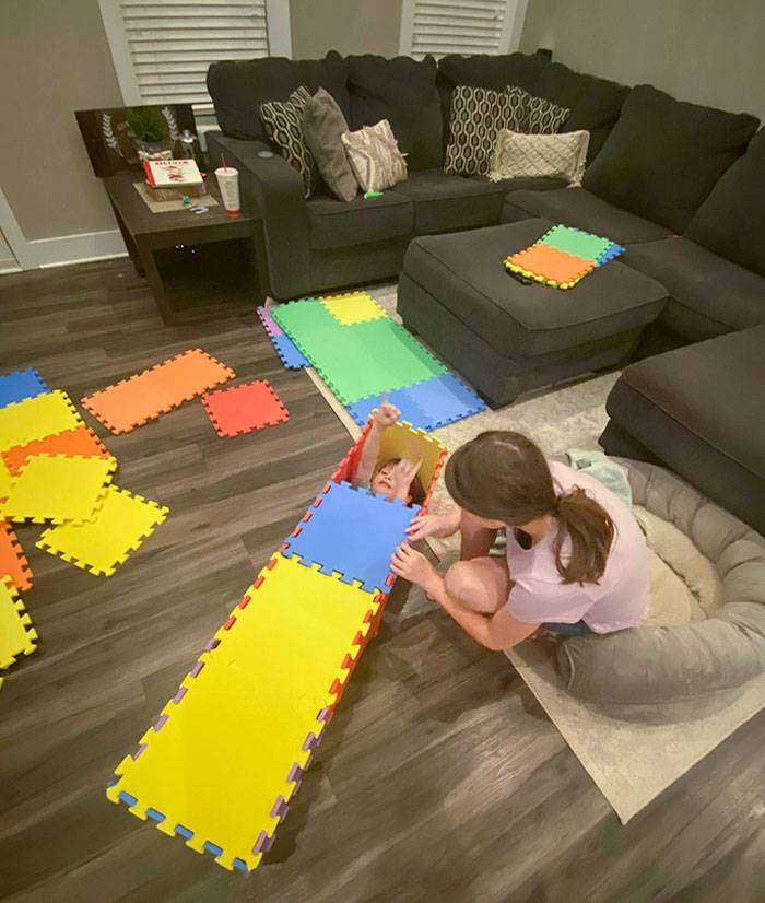 kid making a coffin for sibling out of interlocking foam mats