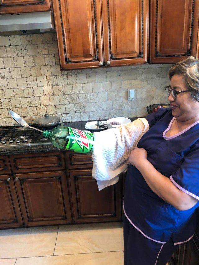 woman using empty pop bottle as hand guard for frying