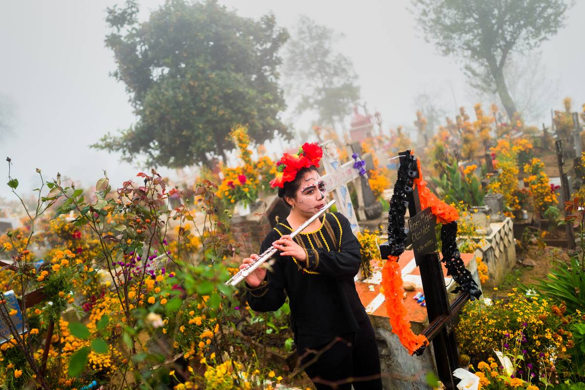 A woman plays the flute to celebrate the Day Of The Dead in Mexico.