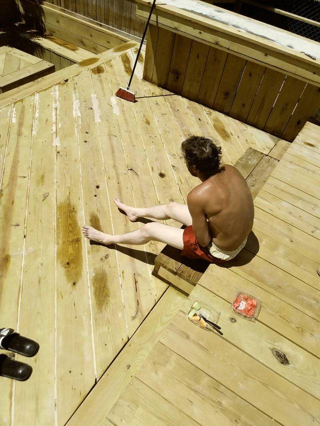 man with very pale legs and very tanned back sitting outside