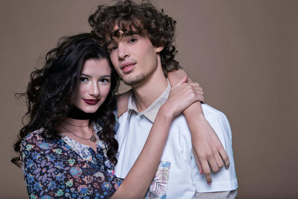 a fashionable couple looking at the camera smiling