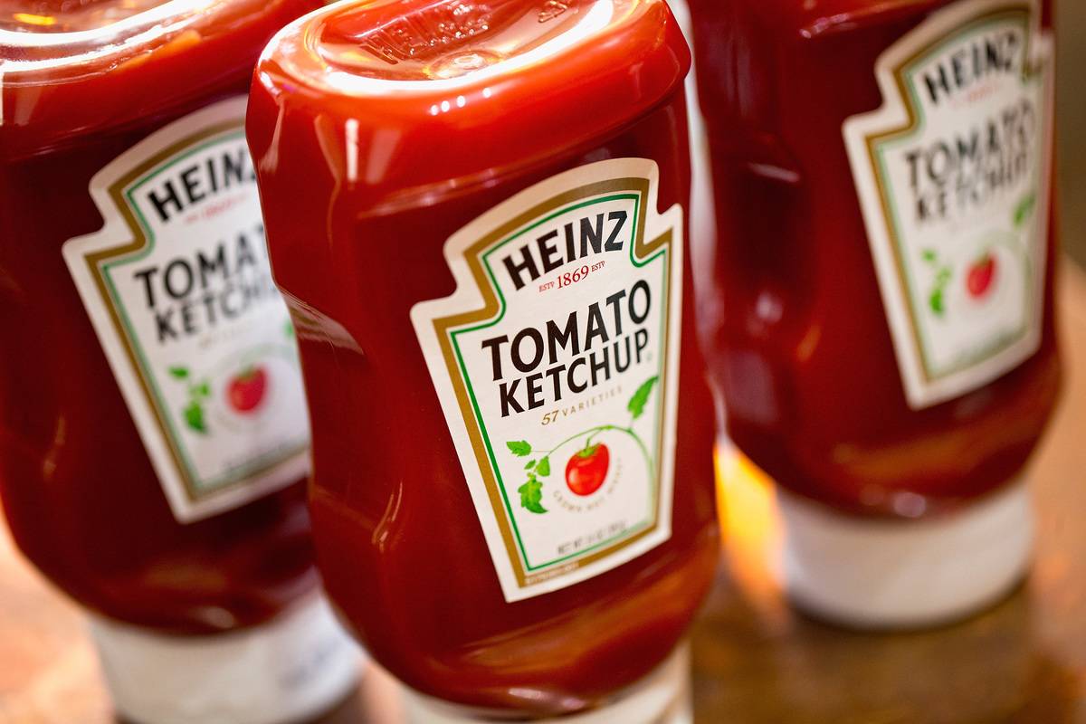 Bottles of ketchup stand on a table.