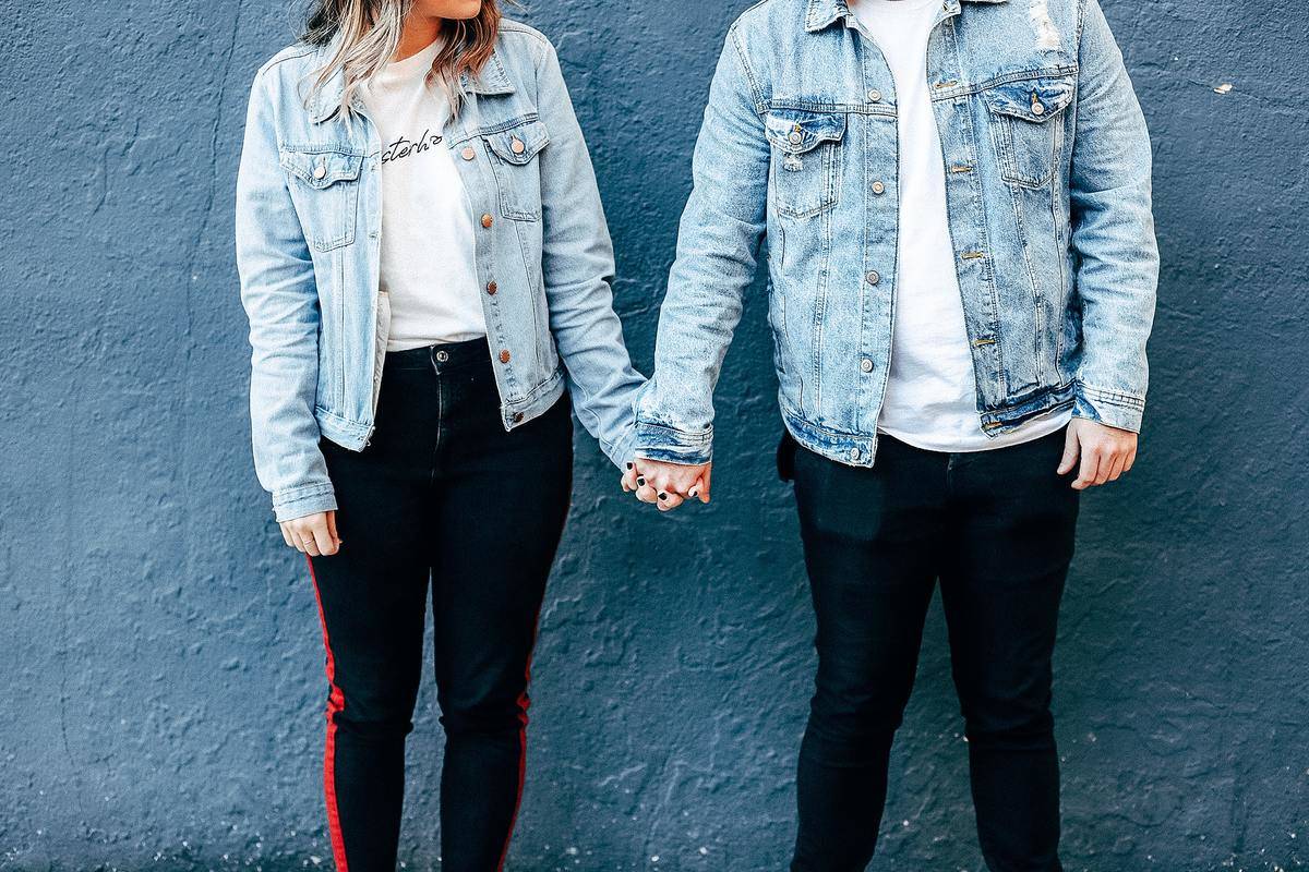 couple holding hands wearing matching jean jackets