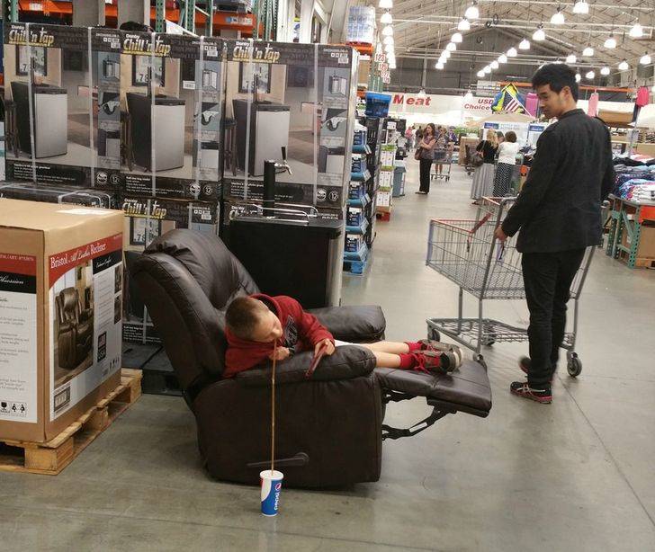kid sitting in recliner and drinking pepsi from a long straw at Costco