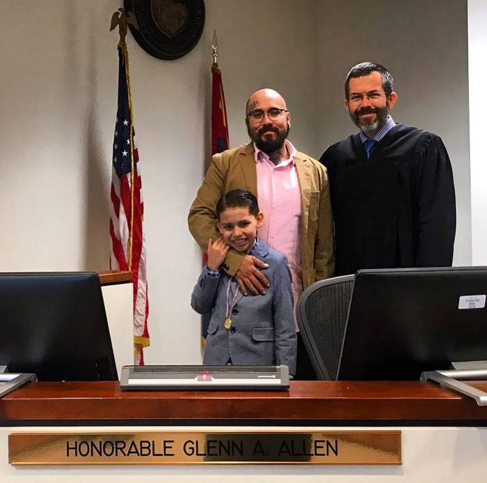 boy being adopted next to judge