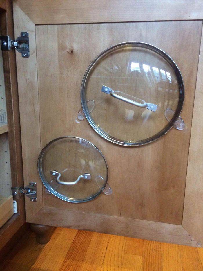 using stick-on hooks to hold pot lids to inside of cabinet