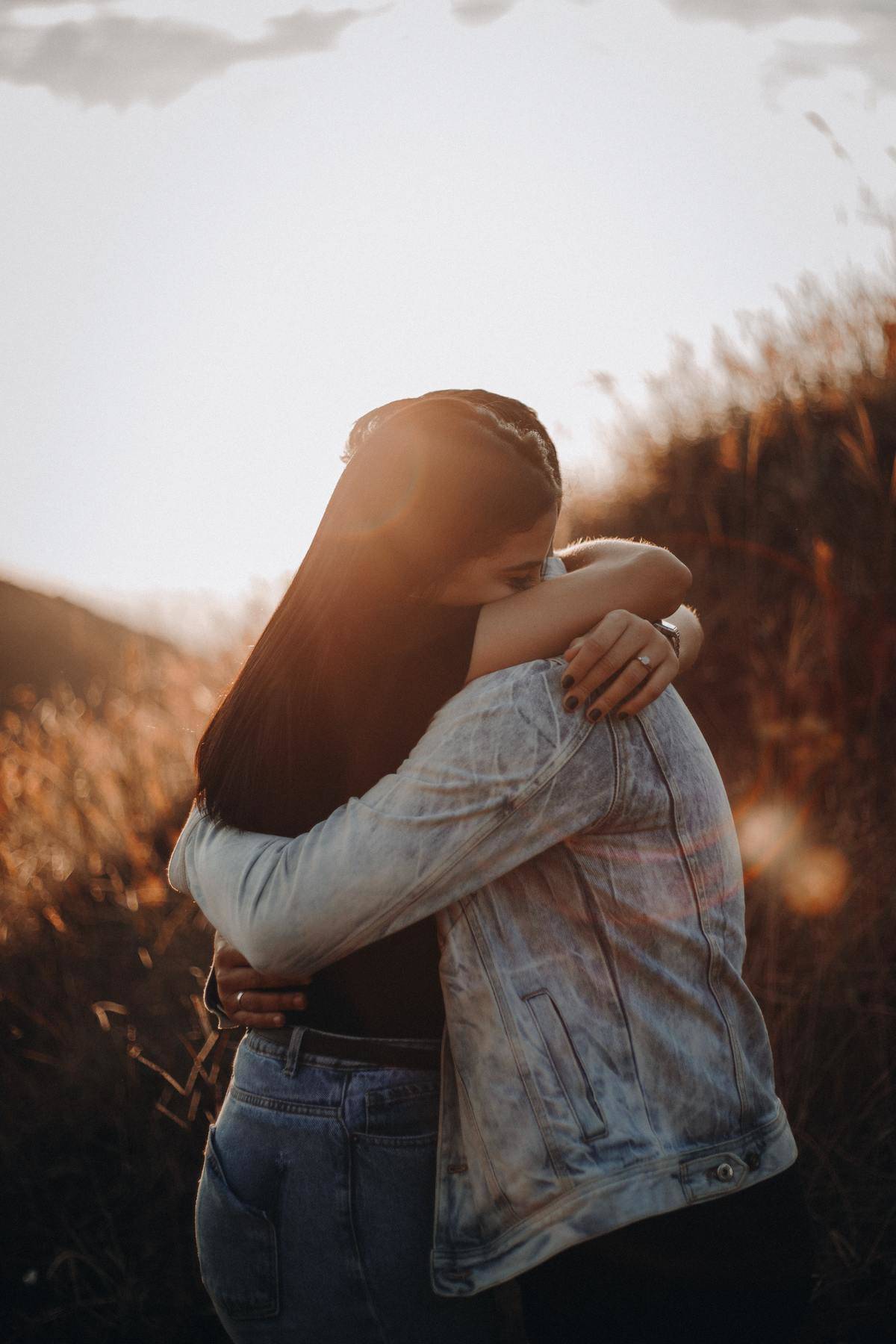 man and woman hug in a field