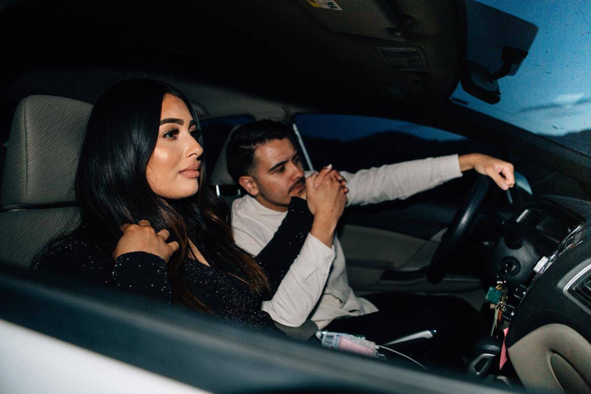 man and woman sit in a car driving