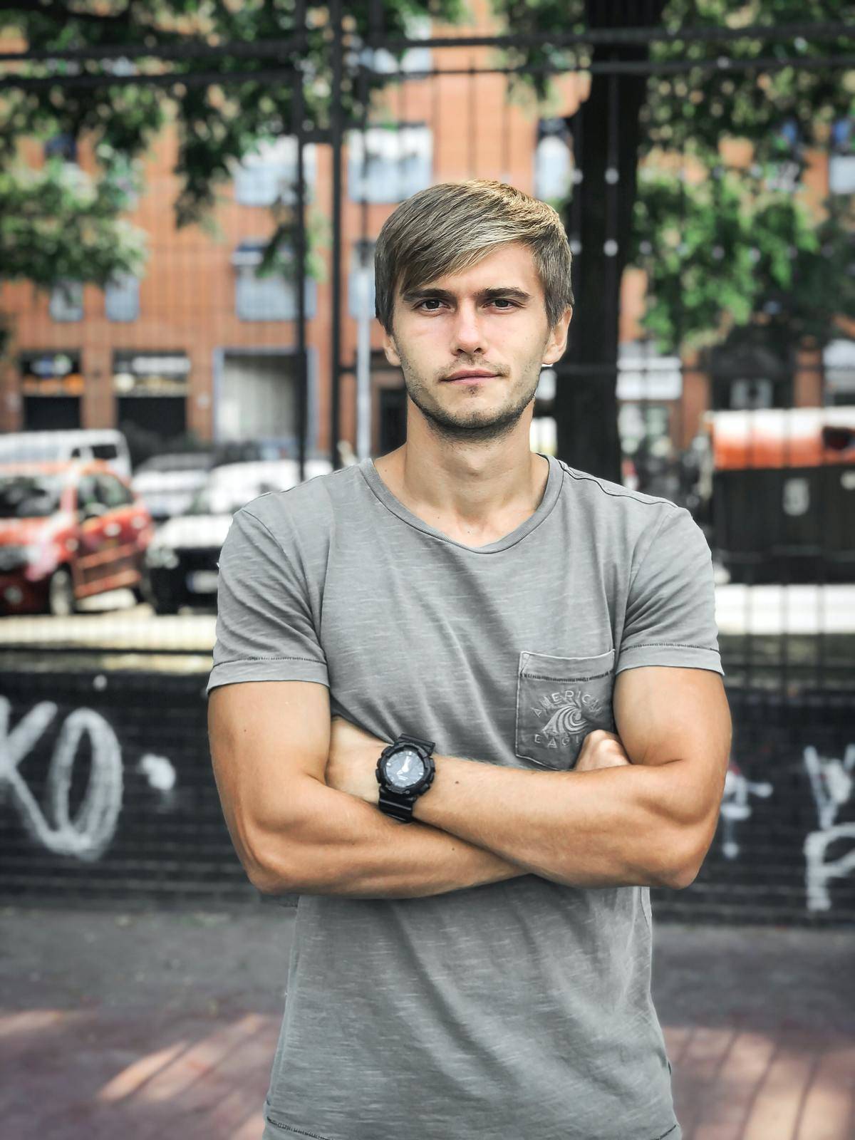 man crosses his arm on the street