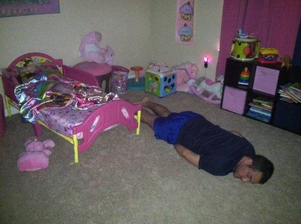 man laying beside daughter's bed
